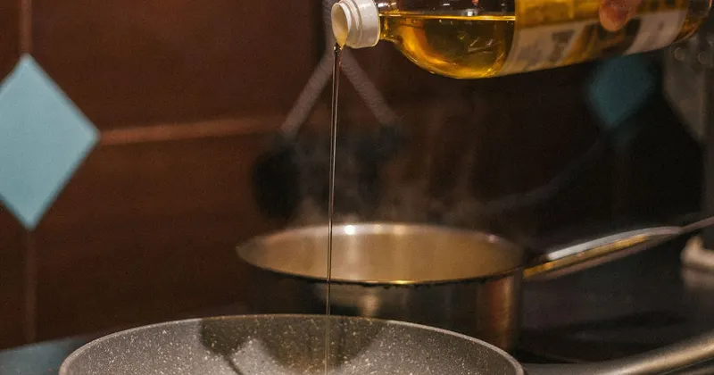 Person pouring cooking oil in a pan for kitchen cleaning hack
