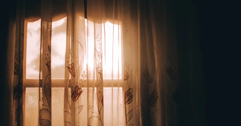 Warm sunlight and steam filtering through window curtains