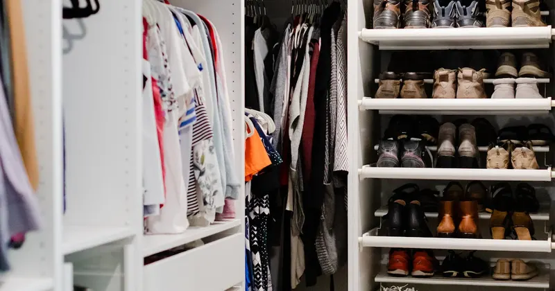 Organized walk-in closet with clothes and shoes on shelves