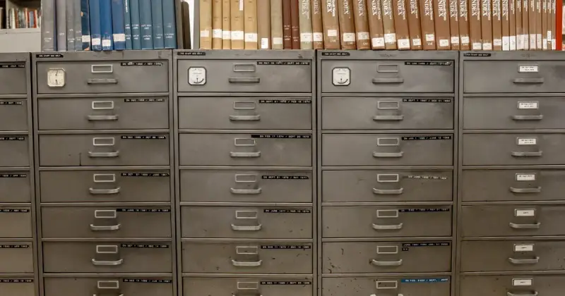 Gray steel filing cabinet with organized document drawers