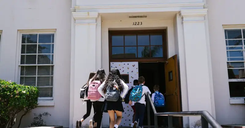 Students with backpacks heading back to school in autumn