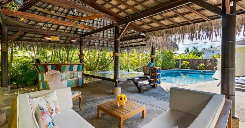 Serene backyard featuring a swimming pool, lush garden, and wooden deck in Antalya, Turkey.
