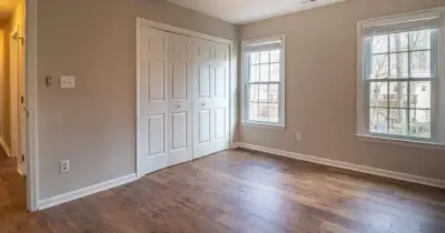 Empty living room with moving boxes and freshly cleaned hardwood floors
