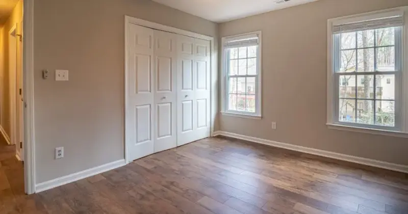 Empty living room with moving boxes and freshly cleaned hardwood floors