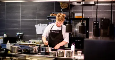 Interior of kitchen in modern restaurant with piles of plates and other different assorted utensils