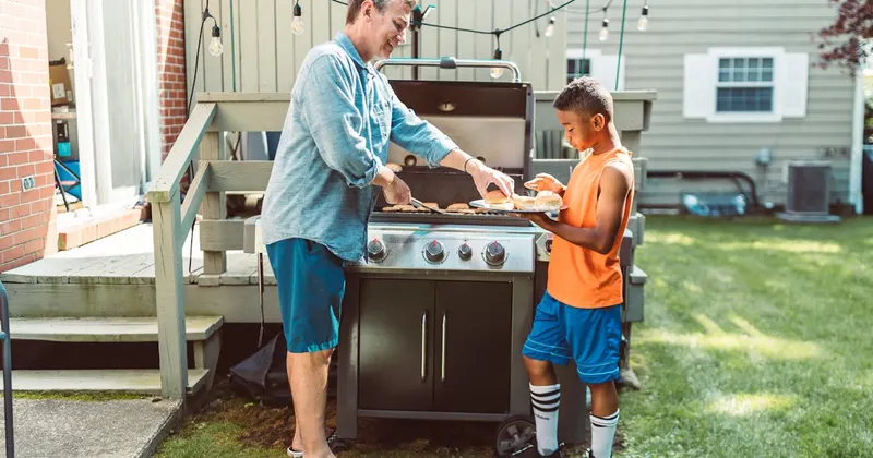 Father and son grilling together on the backyard