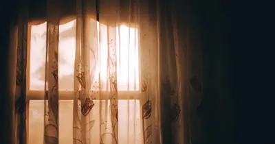 Warm sunlight and steam filtering through window curtains