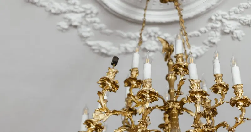 Gold chandelier hanging on a ceiling in an elegant room