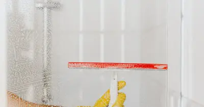 Professional house cleaner wiping a kitchen surface with yellow gloves