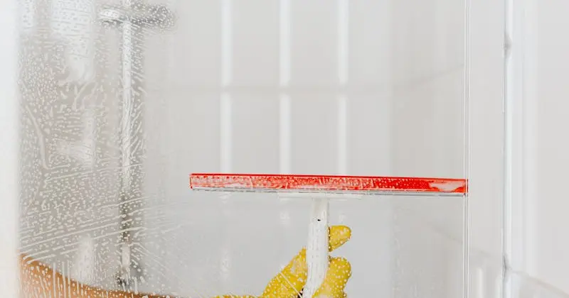 Professional house cleaner wiping a kitchen surface with yellow gloves