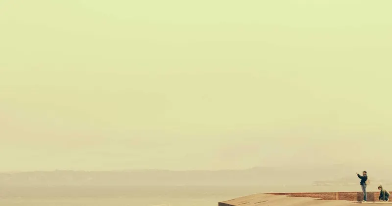 Woman mopping a vinyl plank floor in a tidy living room